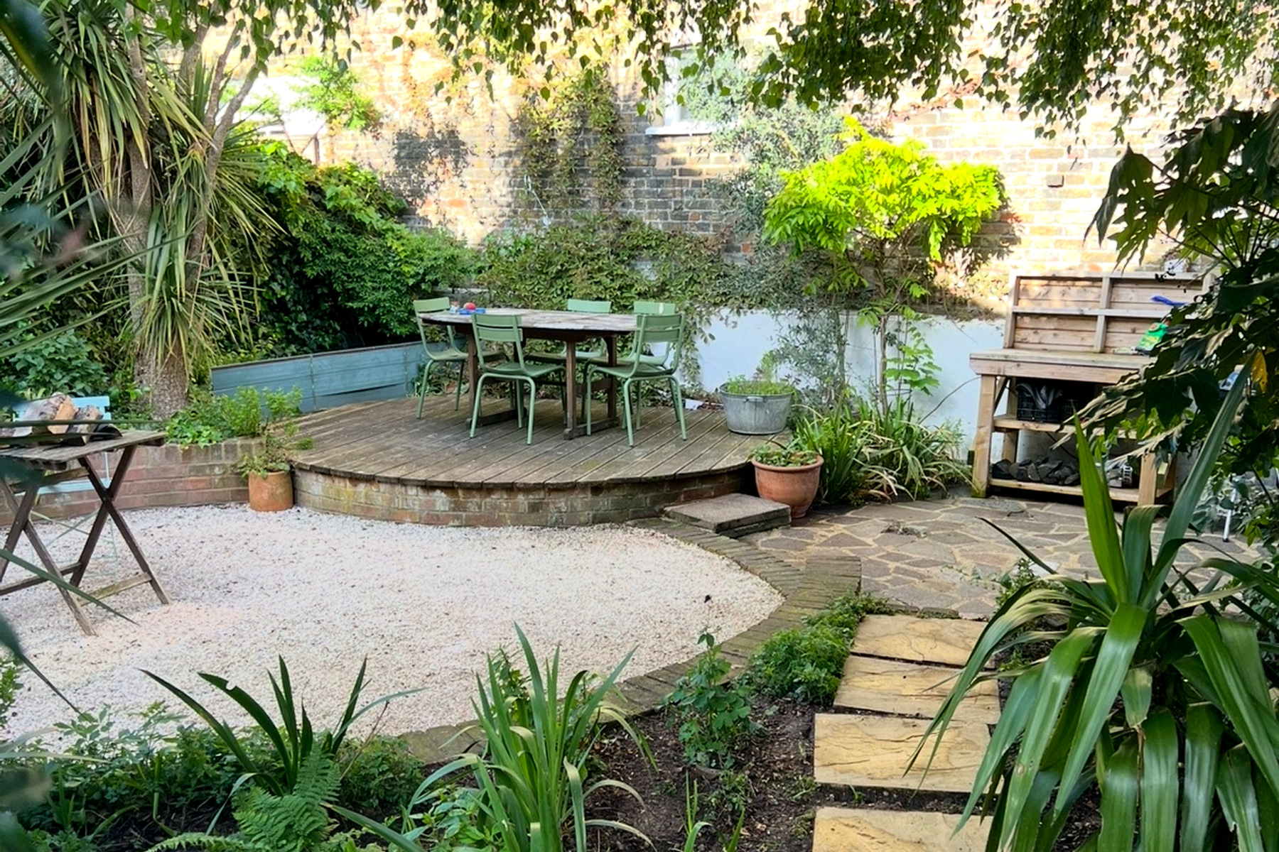 A lush, well-maintained garden patio and decking area with seating